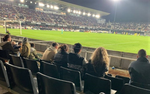 Los tres jóvenes y una de las orientadoras, en las gradas durante el partido